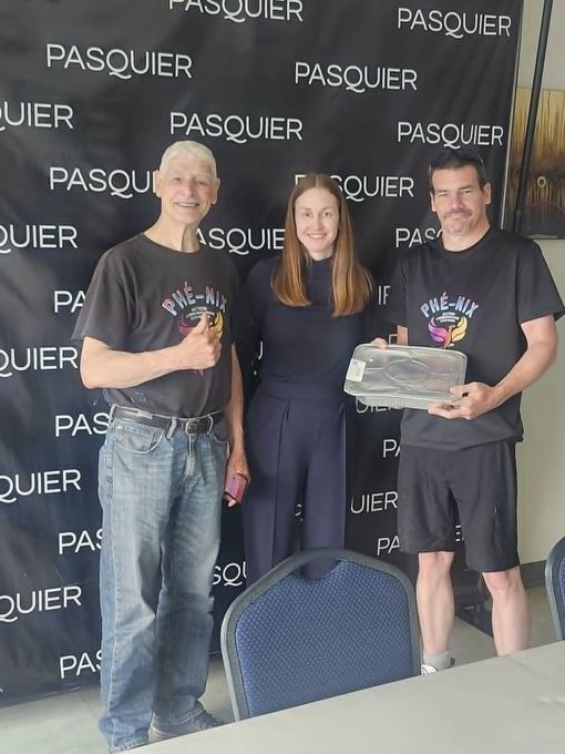 Remise de denrées par un commanditaire à deux bénévoles de Phé-Nix