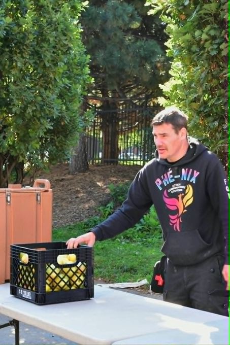 Un bénévole de Phé-Nix prépare les caisses de fruits avant la distribution